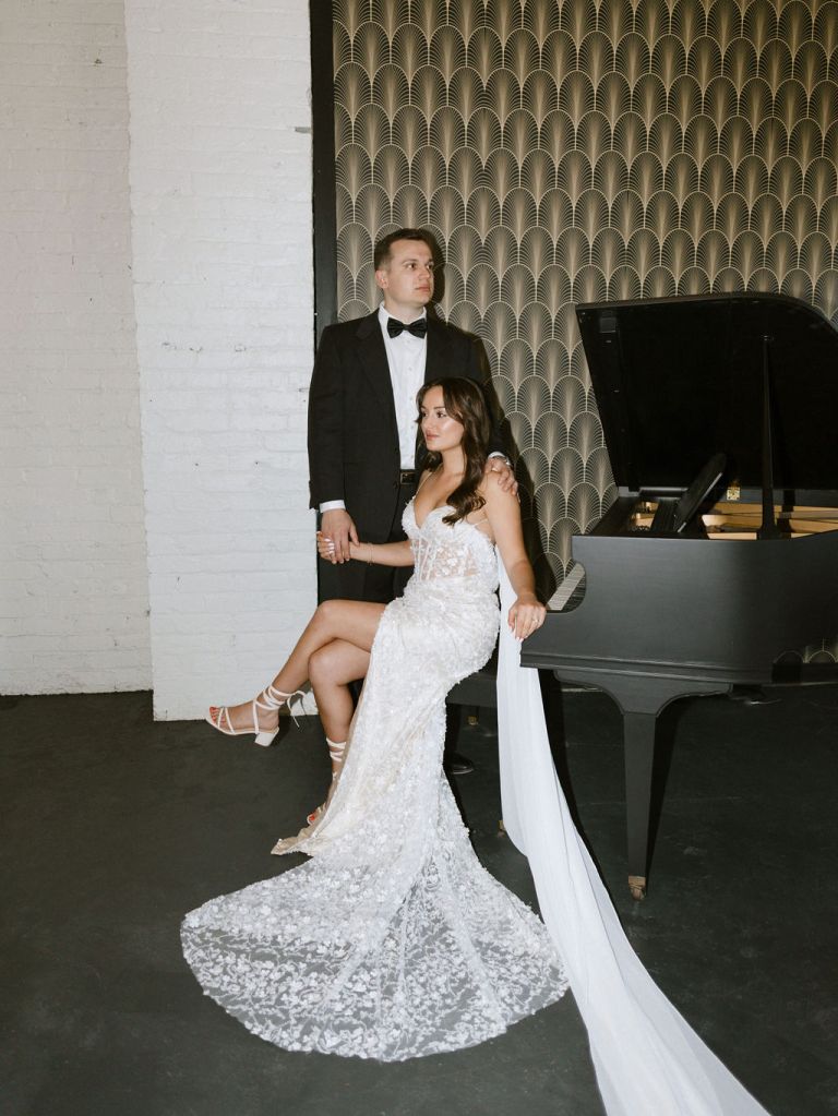 Bride and groom sitting at the grand piano at Sundee Event Venue